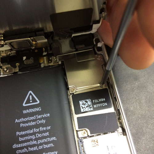 iPhone修理専用のドライバーで慎重にネジを外していきます
